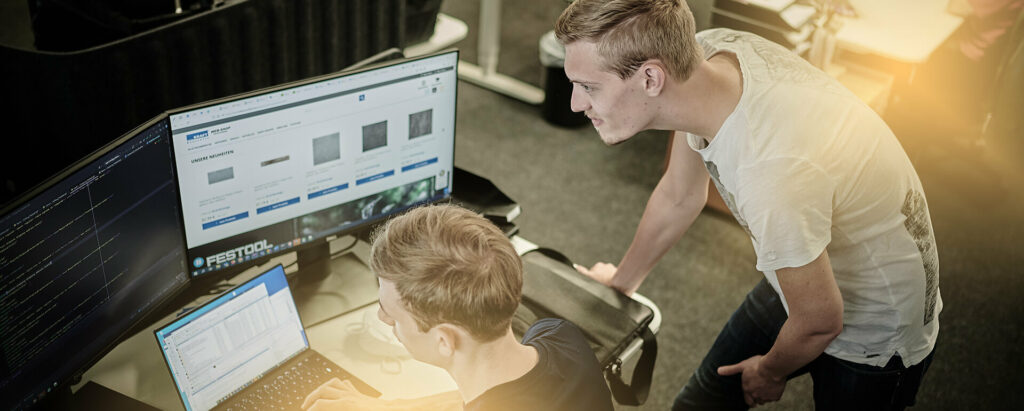 Entwickler sitzen vor dem Laptop und arbeiten am Code